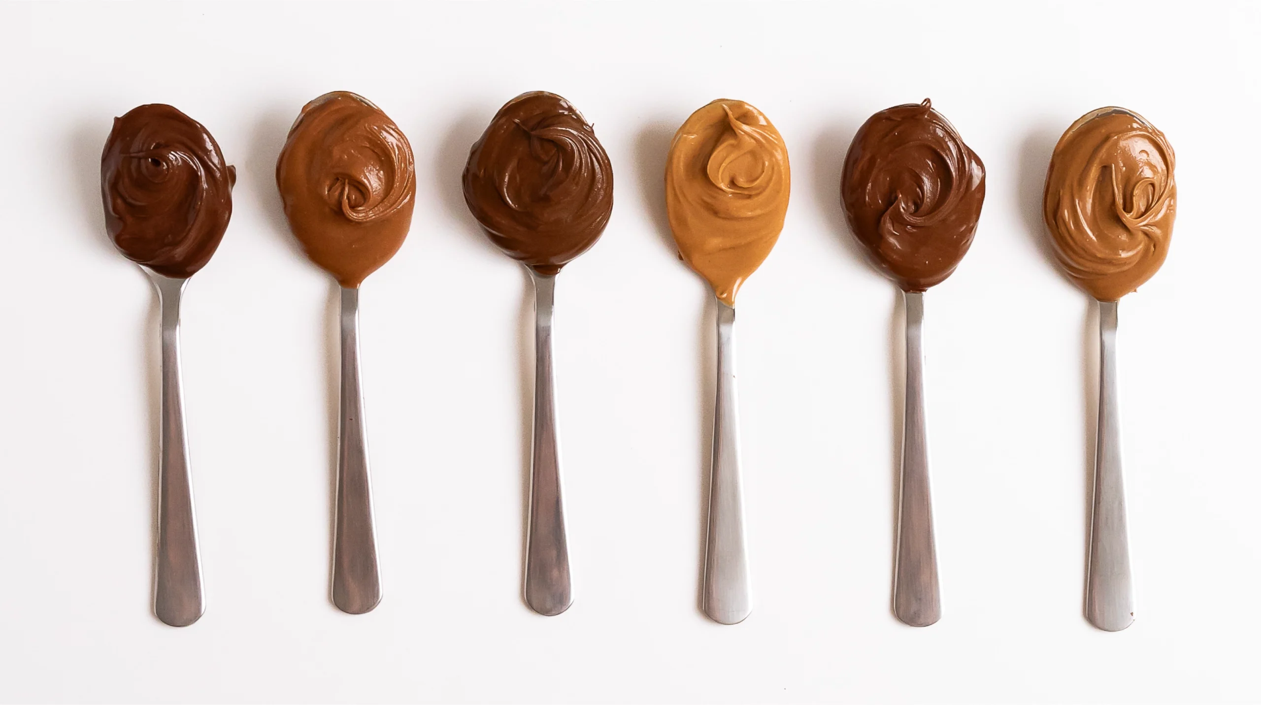 several varieties of hazelnut butter on spoons