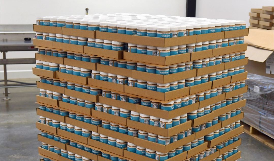 nutlicious spread next to hazelnuts in various stages of processing